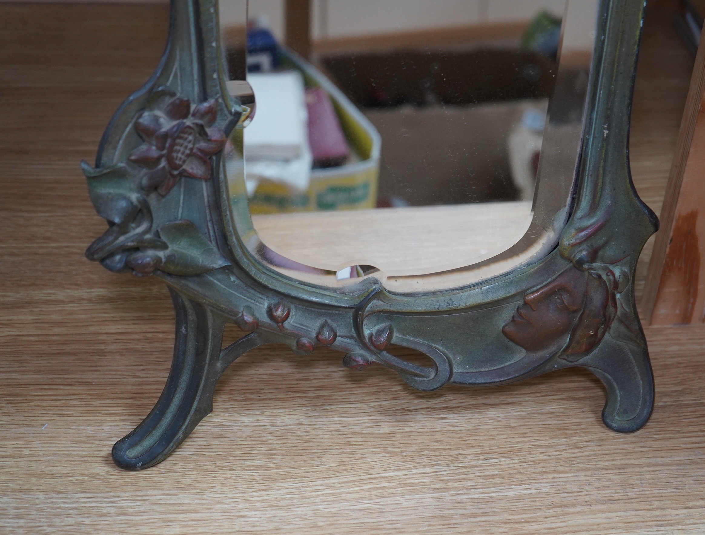 An Art Nouveau painted spelter mirror, signed and stamped on reverse, 44cm high. Condition - front has some wear, back has easel stand missing